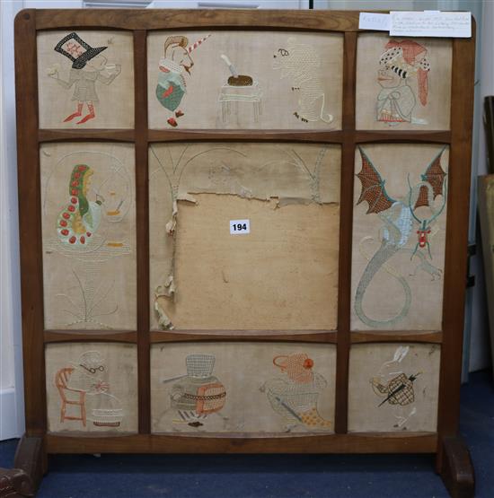 A Cotswolds School fruitwood fire screen with panels of hand embroidery scenes from Alice in Wonderland